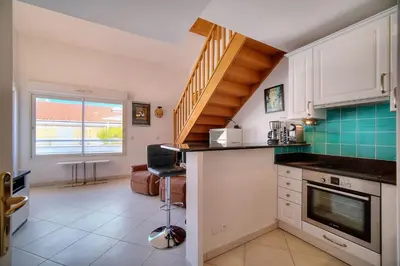 a kitchen with white cabinets and a staircase at REF 1766 - Cannes Center - Apartment for rent in Cannes