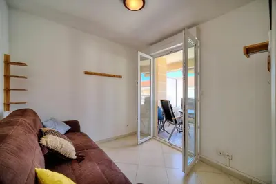 a living room with a brown couch and a sliding glass door at REF 1766 - Cannes Center - Apartment for rent in Cannes