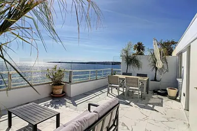 a balcony with a table and chairs and a view of the water at REF 1769 - Cannes - Sea view penthouse for rent in Cannes