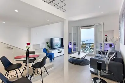 a living room with a couch and a table and chairs at REF 1196 - Cannes Croisette - Sea view apartment for rent in Cannes