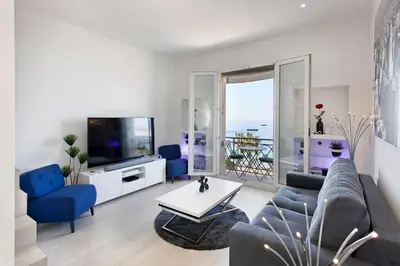 a living room with a couch and a tv at REF 1196 - Cannes Croisette - Sea view apartment for rent in Cannes