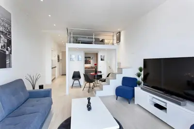 a living room with a blue couch and a tv at REF 1196 - Cannes Croisette - Sea view apartment for rent in Cannes