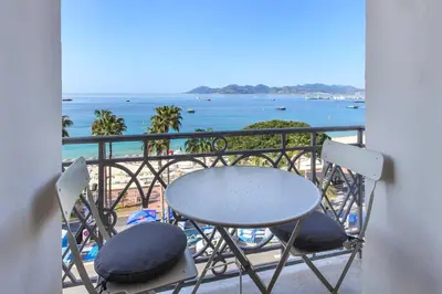 a table and chairs on a balcony with the ocean at REF 1196 - Cannes Croisette - Sea view apartment for rent in Cannes