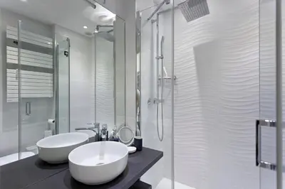 a bathroom with two sinks and a glass shower at REF 1196 - Cannes Croisette - Sea view apartment for rent in Cannes