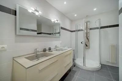 a white bathroom with a sink and a shower at REF 1389 - Cannes Center - Apartment for rent in Cannes