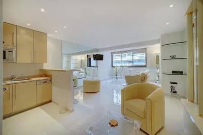 a large kitchen with a yellow chair and a living room at REF 1389 - Cannes Center - Apartment for rent in Cannes