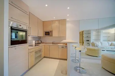 a kitchen with wooden cabinets and a bar in it at REF 1389 - Cannes Center - Apartment for rent in Cannes