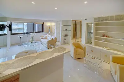 a large living room with yellow chairs and a table at REF 1389 - Cannes Center - Apartment for rent in Cannes