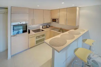 a kitchen with wooden cabinets and a counter top at REF 1389 - Cannes Center - Apartment for rent in Cannes