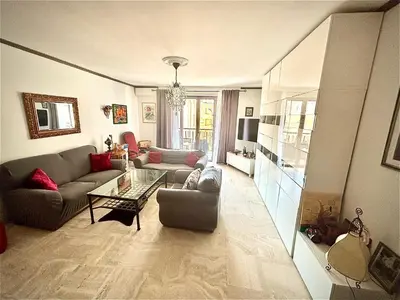 a living room with a couch and a table at Évasion aux Portes de Cannes 100m2 Lumineux 2 Chambres Terrasse et Commerces in Le Cannet