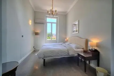 a bedroom with a bed and a table and a window at Luxury 2-floor Flat minutes walk to Croisette and City Center in Cannes