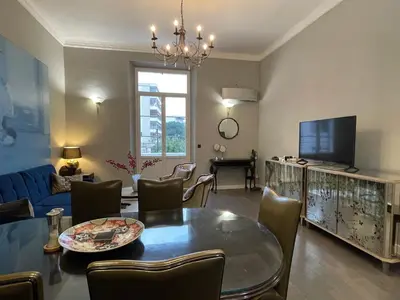 a living room with a table and a tv at Luxury 2-floor Flat minutes walk to Croisette and City Center in Cannes