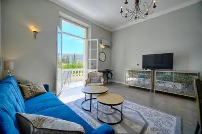 a living room with a blue couch and a table at Luxury 2-floor Flat minutes walk to Croisette and City Center in Cannes
