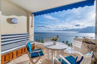 a balcony with a table and chairs and the ocean at Appartement cosy à Cannes - 40 m² avec balcon et vue mer in Cannes