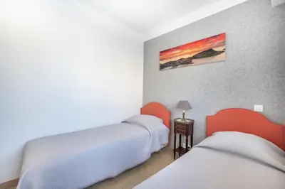 a room with two beds and a table with a lamp at Appartement cosy à Cannes - 40 m² avec balcon et vue mer in Cannes