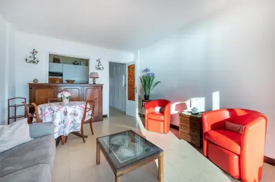 a living room with red chairs and a table at Appartement cosy à Cannes - 40 m² avec balcon et vue mer in Cannes