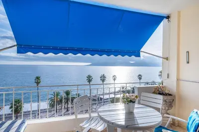 a balcony with a table and chairs and the ocean at Appartement cosy à Cannes - 40 m² avec balcon et vue mer in Cannes
