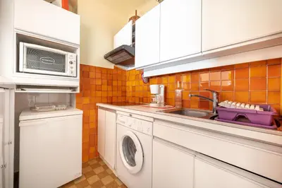 a kitchen with a washing machine and a sink at Appartement cosy à Cannes - 40 m² avec balcon et vue mer in Cannes