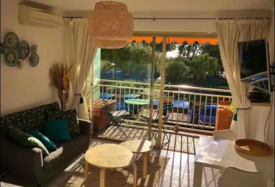 a living room with a couch and a balcony at Le Bleuette - Festivals 10min - face plages ! in Cannes