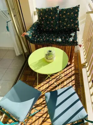 a room with a green table and a chair at Le Bleuette - Festivals 10min - face plages ! in Cannes