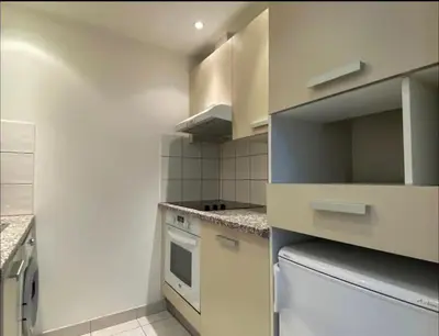 a kitchen with white cabinets and a stove at Le Bleuette - Festivals 10min - face plages ! in Cannes