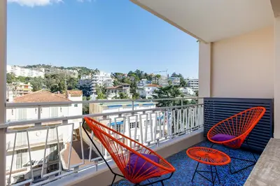two chairs on a balcony with a view of a city at Les Légendes YourHostHelper in Cannes