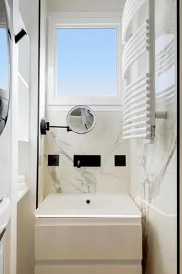 a white bathroom with a sink and a window at Les Légendes YourHostHelper in Cannes