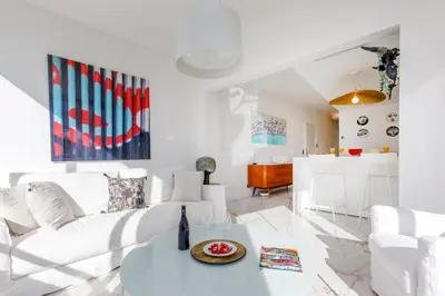 a white living room with a white couch and a table at Les Légendes YourHostHelper in Cannes