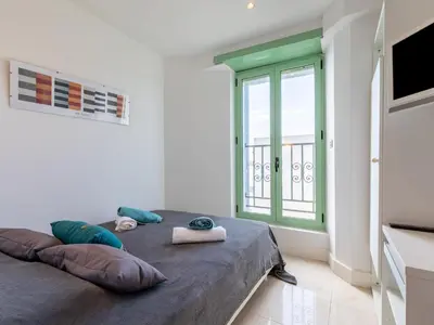 a bedroom with a bed with pillows and a window at Apartment Les Araucarias by Interhome in Cannes