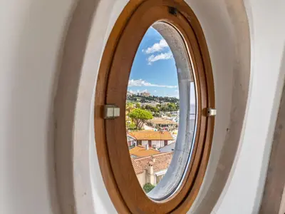 a circular window with a view of a city at Apartment Les Araucarias by Interhome in Cannes