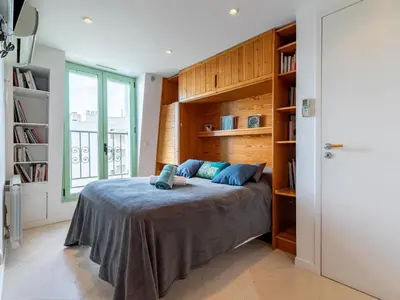 a bedroom with a bed and a book shelf at Apartment Les Araucarias by Interhome in Cannes
