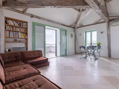 a living room with a couch and a table with chairs at Apartment Les Araucarias by Interhome in Cannes