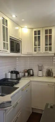 a kitchen with white cabinets and a microwave at STUDIO CANNES STELLAMARE in Cannes