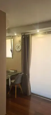 a room with a table and a curtain and a chair at STUDIO CANNES STELLAMARE in Cannes