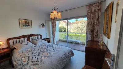 a bedroom with a bed and a large window at Centre Cannes gd 2p terrasse parking 10mn palais plage in Cannes