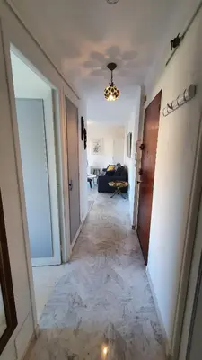 a hallway leading to a living room with a chandelier at Centre Cannes gd 2p terrasse parking 10mn palais plage in Cannes