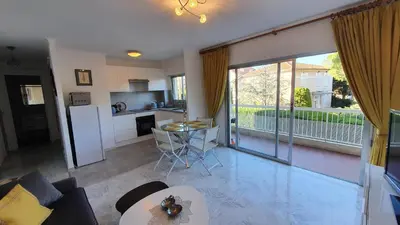 a living room with a couch and a kitchen with a large window at Centre Cannes gd 2p terrasse parking 10mn palais plage in Cannes