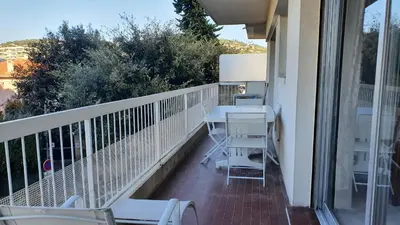 a balcony with a table and chairs on it at Centre Cannes gd 2p terrasse parking 10mn palais plage in Cannes