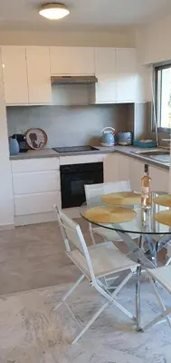 a kitchen with a table and chairs in a kitchen at Centre Cannes gd 2p terrasse parking 10mn palais plage in Cannes