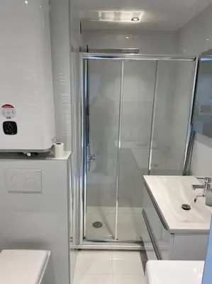 a white bathroom with a shower and a sink at Eider croisette in Cannes