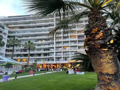 a palm tree in front of a large building at Eider croisette in Cannes