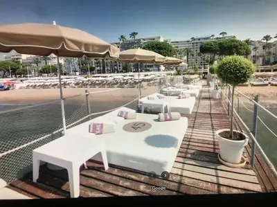 a row of tables with umbrellas on a beach at Eider croisette in Cannes