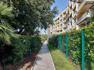 a sidewalk in front of a building with a fence at Trident in Cannes