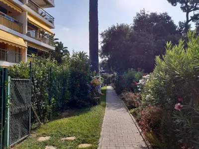 a path in a garden next to a building at Trident in Cannes