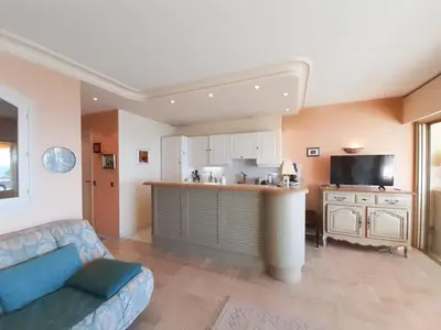 a living room with a couch and a kitchen at Trident in Cannes