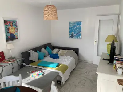 a bedroom with a bed and a table in it at Appart proche plage avec grand balcon in Cannes