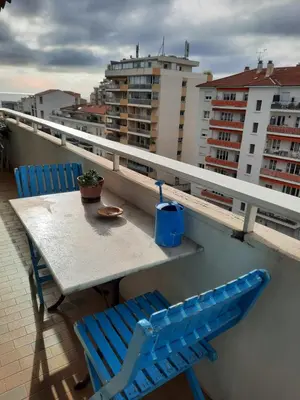 a table and chairs on a balcony with buildings at Appart proche plage avec grand balcon in Cannes