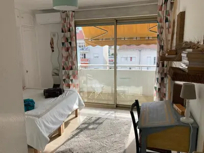 a bedroom with a bed and a large window at Appart proche plage avec grand balcon in Cannes
