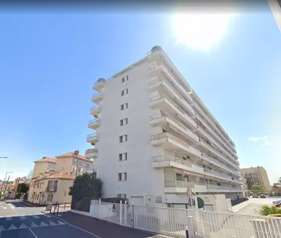 a white building with balconies on the side of it at Appart proche plage avec grand balcon in Cannes