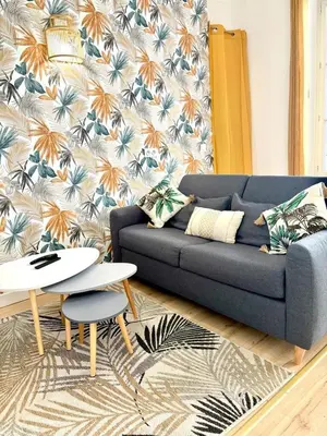 a living room with a blue couch and a table at Les Halles Forville - Palais, plages, wifi, clim in Cannes
